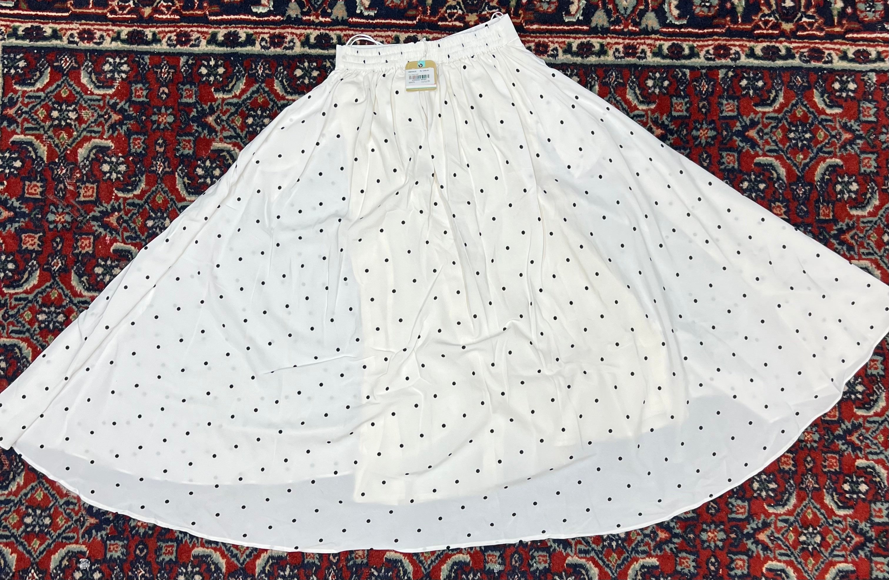 A white A-line skirt with a black polka dot pattern, 